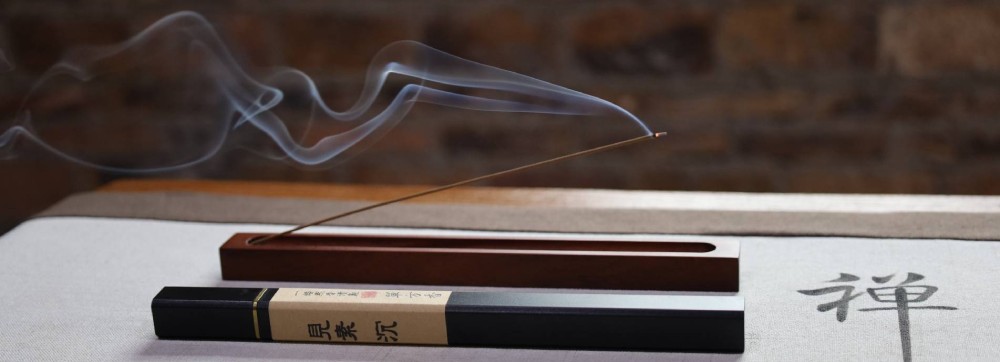 Lit natural incense stick with smoke in meditation room